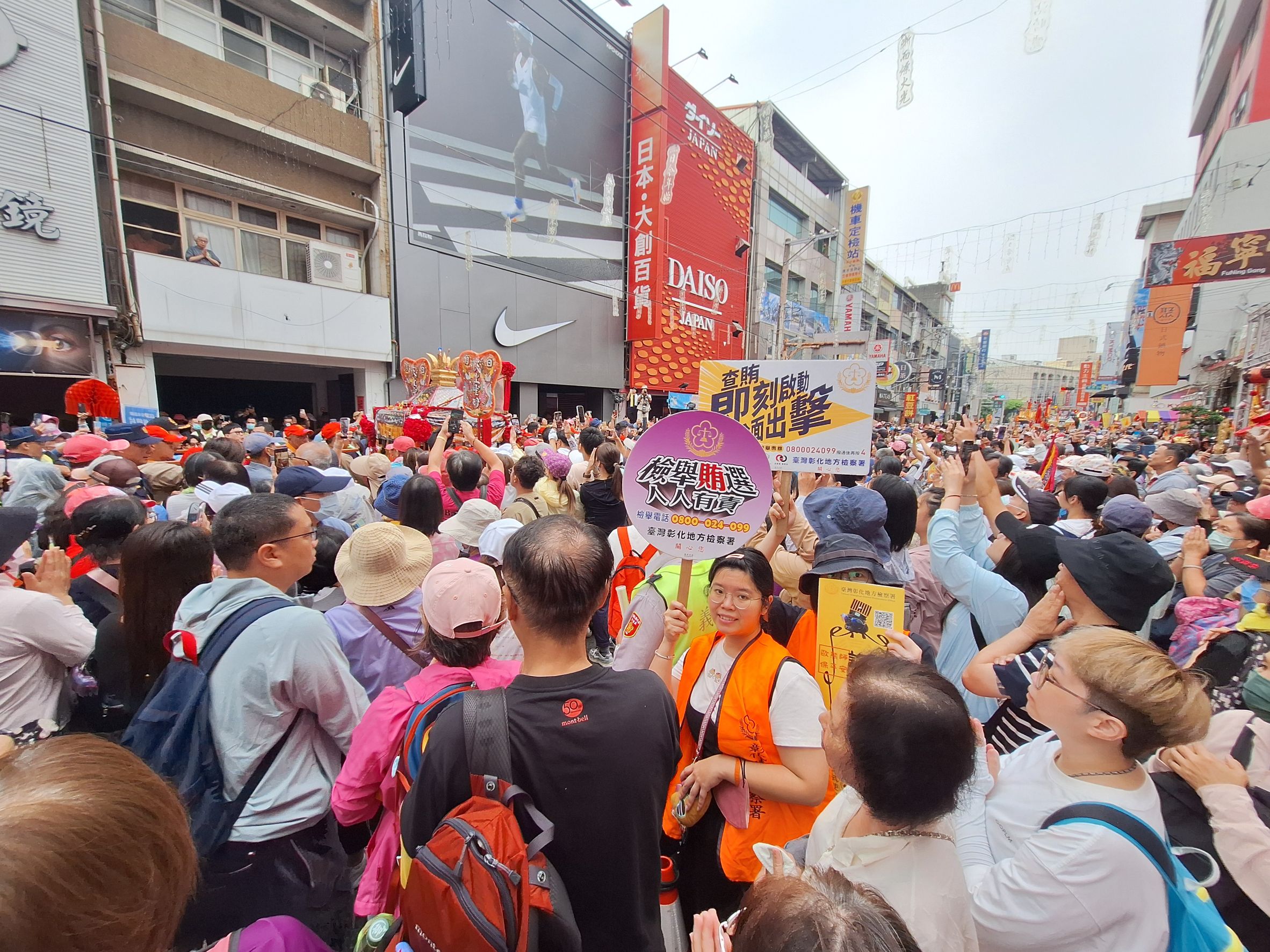 宣導人員於媽祖鑾轎旁高舉宣導標語
